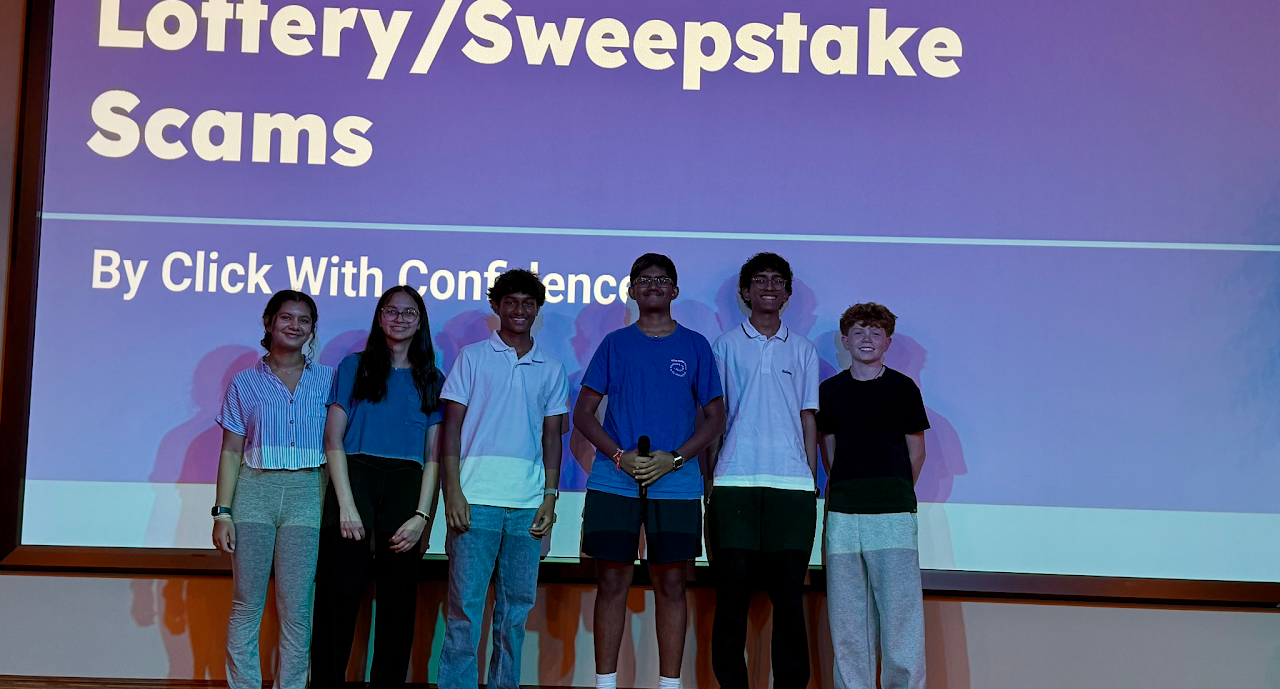 Click With Confidence students in front of a Lottery/Sweepstake Scams presentation slide